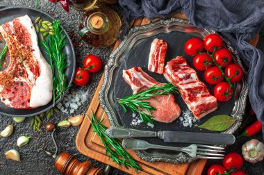 Mutfak masasında aksesuarları pişirme ile bir kompozisyon içinde metalik bir arka plan üzerinde çiğ et