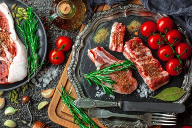 Mutfak masasında aksesuarları pişirme ile bir kompozisyon içinde metalik bir arka plan üzerinde çiğ et