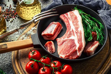 Mutfak masasında aksesuarları pişirme ile bir kompozisyon içinde metalik bir arka plan üzerinde çiğ et