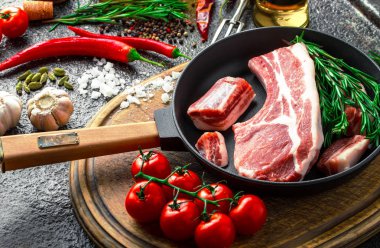 Mutfak masasında aksesuarları pişirme ile bir kompozisyon içinde metalik bir arka plan üzerinde çiğ et