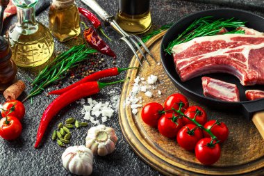 Mutfak masasında aksesuarları pişirme ile bir kompozisyon içinde metalik bir arka plan üzerinde çiğ et