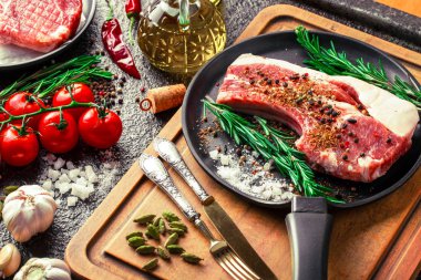 Mutfak masasında aksesuarları pişirme ile bir kompozisyon içinde metalik bir arka plan üzerinde çiğ et