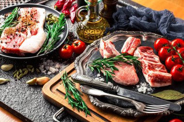 Mutfak masasında aksesuarları pişirme ile bir kompozisyon içinde metalik bir arka plan üzerinde çiğ et