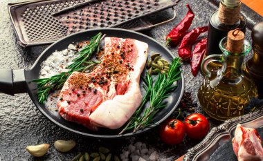 Mutfak masasında aksesuarları pişirme ile bir kompozisyon içinde metalik bir arka plan üzerinde çiğ et