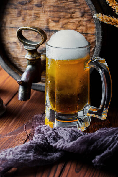 Light foam beer in a glass on an old background