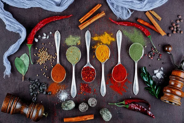 Spices for cooking with kitchen accessories on an old background