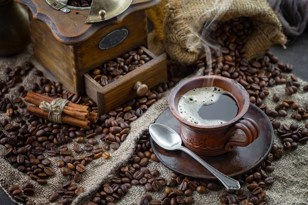 コーヒー豆の背景にカップでコーヒー 古い背景に — ストック写真