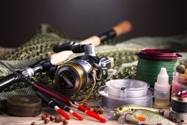 Balıkçılık çubuklar ve spinnings tablosundaki eski arka plan üzerinde balıkçılık için aksesuarlar ile kompozisyon