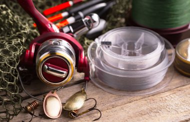 Balıkçılık çubuklar ve spinnings tablosundaki eski arka plan üzerinde balıkçılık için aksesuarlar ile kompozisyon