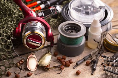 Balıkçılık çubuklar ve spinnings tablosundaki eski arka plan üzerinde balıkçılık için aksesuarlar ile kompozisyon