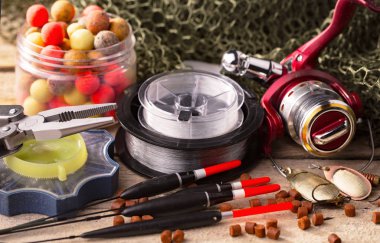 Balıkçılık çubuklar ve spinnings tablosundaki eski arka plan üzerinde balıkçılık için aksesuarlar ile kompozisyon