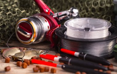 Balıkçılık çubuklar ve spinnings tablosundaki eski arka plan üzerinde balıkçılık için aksesuarlar ile kompozisyon