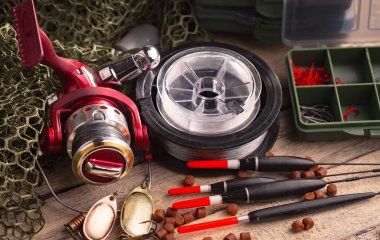 Balıkçılık çubuklar ve spinnings tablosundaki eski arka plan üzerinde balıkçılık için aksesuarlar ile kompozisyon