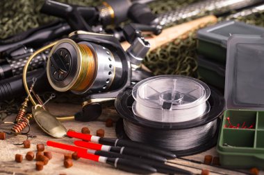 Balıkçılık çubuklar ve spinnings tablosundaki eski arka plan üzerinde balıkçılık için aksesuarlar ile kompozisyon