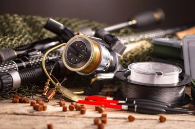 Balıkçılık çubuklar ve spinnings tablosundaki eski arka plan üzerinde balıkçılık için aksesuarlar ile kompozisyon