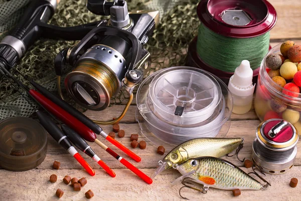 Balıkçılık çubuklar ve spinnings tablosundaki eski arka plan üzerinde balıkçılık için aksesuarlar ile kompozisyon