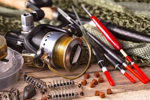 Balıkçılık çubuklar ve spinnings tablosundaki eski arka plan üzerinde balıkçılık için aksesuarlar ile kompozisyon