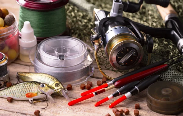 Balıkçılık çubuklar ve spinnings tablosundaki eski arka plan üzerinde balıkçılık için aksesuarlar ile kompozisyon