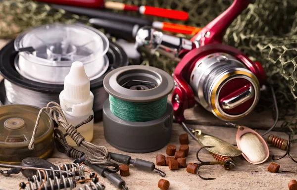 Balıkçılık çubuklar ve spinnings tablosundaki eski arka plan üzerinde balıkçılık için aksesuarlar ile kompozisyon