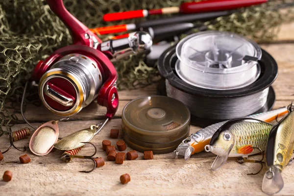 Balıkçılık çubuklar ve spinnings tablosundaki eski arka plan üzerinde balıkçılık için aksesuarlar ile kompozisyon