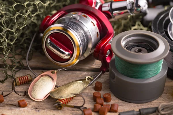 Balıkçılık çubuklar ve spinnings tablosundaki eski arka plan üzerinde balıkçılık için aksesuarlar ile kompozisyon