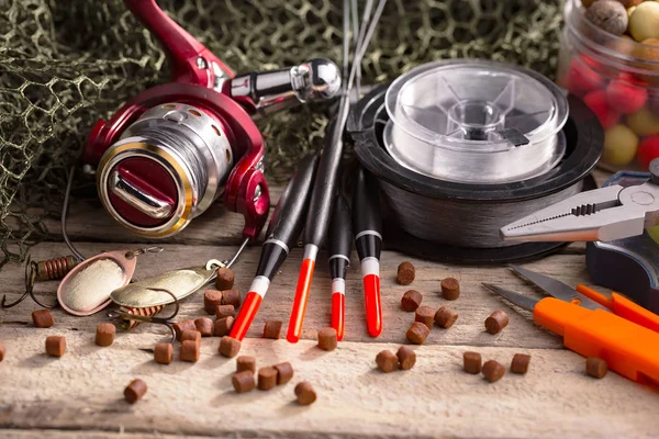 Balıkçılık çubuklar ve spinnings tablosundaki eski arka plan üzerinde balıkçılık için aksesuarlar ile kompozisyon