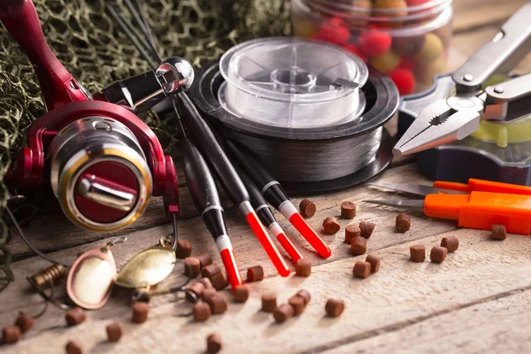 Balıkçılık çubuklar ve spinnings tablosundaki eski arka plan üzerinde balıkçılık için aksesuarlar ile kompozisyon