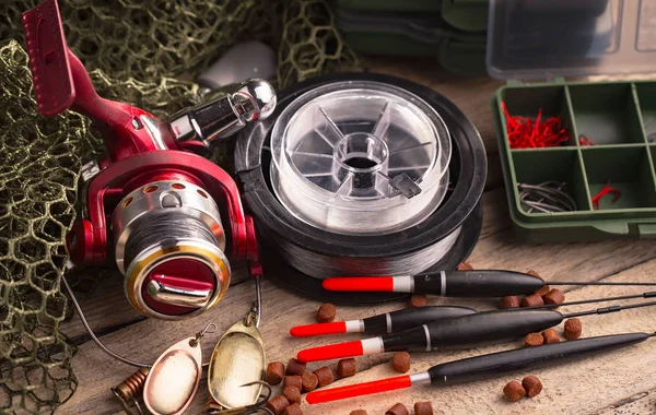 Balıkçılık çubuklar ve spinnings tablosundaki eski arka plan üzerinde balıkçılık için aksesuarlar ile kompozisyon