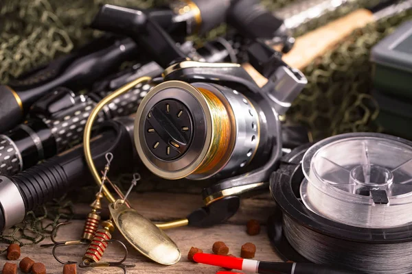 Balıkçılık çubuklar ve spinnings tablosundaki eski arka plan üzerinde balıkçılık için aksesuarlar ile kompozisyon