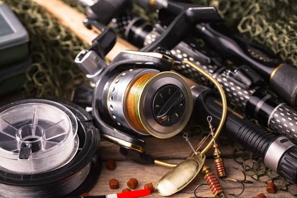 Balıkçılık çubuklar ve spinnings tablosundaki eski arka plan üzerinde balıkçılık için aksesuarlar ile kompozisyon
