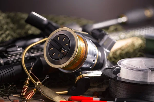 Balıkçılık çubuklar ve spinnings tablosundaki eski arka plan üzerinde balıkçılık için aksesuarlar ile kompozisyon