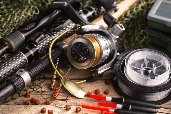 Balıkçılık çubuklar ve spinnings tablosundaki eski arka plan üzerinde balıkçılık için aksesuarlar ile kompozisyon