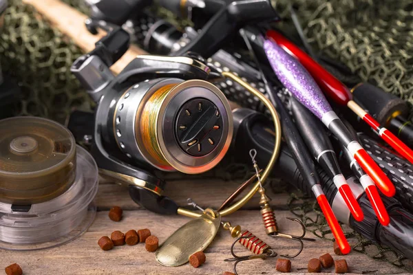 Balıkçılık çubuklar ve spinnings tablosundaki eski arka plan üzerinde balıkçılık için aksesuarlar ile kompozisyon