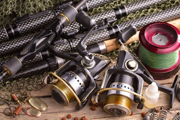 Balıkçılık çubuklar ve spinnings tablosundaki eski arka plan üzerinde balıkçılık için aksesuarlar ile kompozisyon