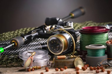 Balıkçılık çubuklar ve spinnings tablosundaki eski arka plan üzerinde balıkçılık için aksesuarlar ile kompozisyon