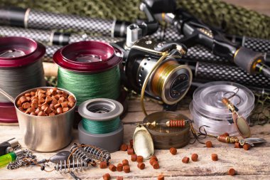 Balıkçılık çubuklar ve spinnings tablosundaki eski arka plan üzerinde balıkçılık için aksesuarlar ile kompozisyon