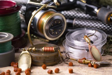 Balıkçılık çubuklar ve spinnings tablosundaki eski arka plan üzerinde balıkçılık için aksesuarlar ile kompozisyon