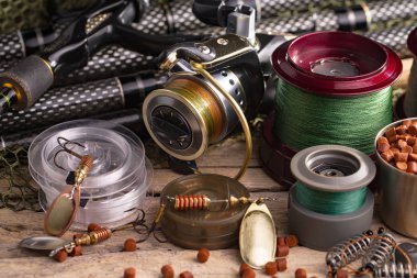 Balıkçılık çubuklar ve spinnings tablosundaki eski arka plan üzerinde balıkçılık için aksesuarlar ile kompozisyon