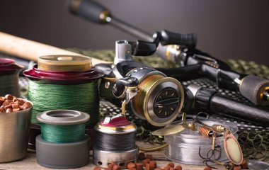 Balıkçılık çubuklar ve spinnings tablosundaki eski arka plan üzerinde balıkçılık için aksesuarlar ile kompozisyon
