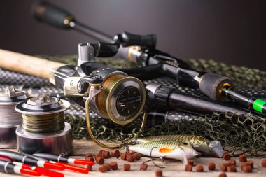 Balıkçılık çubuklar ve spinnings tablosundaki eski arka plan üzerinde balıkçılık için aksesuarlar ile kompozisyon