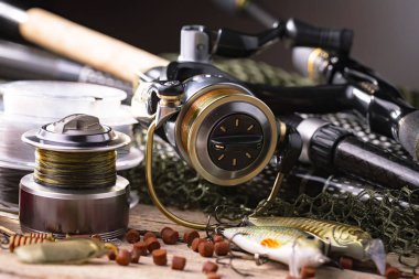 Balıkçılık çubuklar ve spinnings tablosundaki eski arka plan üzerinde balıkçılık için aksesuarlar ile kompozisyon