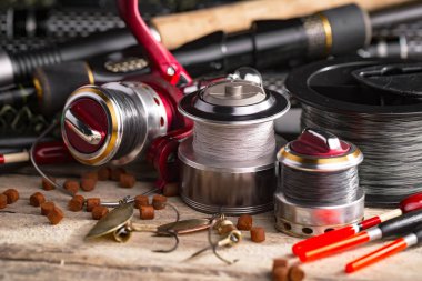 Balıkçılık çubuklar ve spinnings tablosundaki eski arka plan üzerinde balıkçılık için aksesuarlar ile kompozisyon