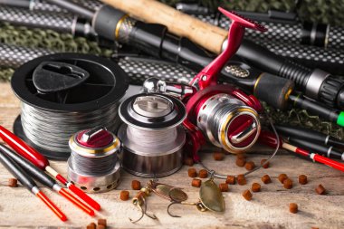 Balıkçılık çubuklar ve spinnings tablosundaki eski arka plan üzerinde balıkçılık için aksesuarlar ile kompozisyon