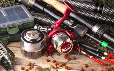 Balıkçılık çubuklar ve spinnings tablosundaki eski arka plan üzerinde balıkçılık için aksesuarlar ile kompozisyon