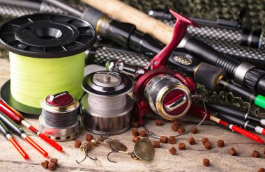 Balıkçılık çubuklar ve spinnings tablosundaki eski arka plan üzerinde balıkçılık için aksesuarlar ile kompozisyon