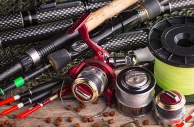 Balıkçılık çubuklar ve spinnings tablosundaki eski arka plan üzerinde balıkçılık için aksesuarlar ile kompozisyon