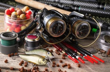 Balıkçılık çubuklar ve spinnings tablosundaki eski arka plan üzerinde balıkçılık için aksesuarlar ile kompozisyon