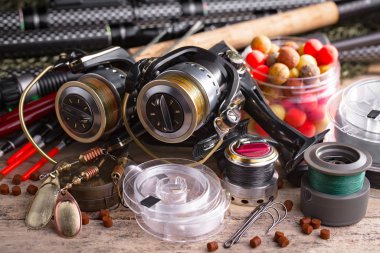 Balıkçılık çubuklar ve spinnings tablosundaki eski arka plan üzerinde balıkçılık için aksesuarlar ile kompozisyon