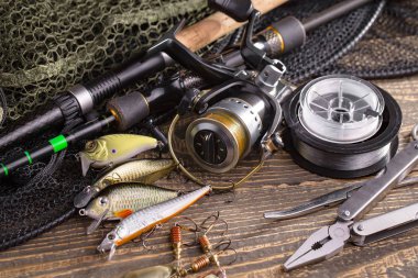 Balıkçılık çubuklar ve spinnings tablosundaki eski arka plan üzerinde balıkçılık için aksesuarlar ile kompozisyon
