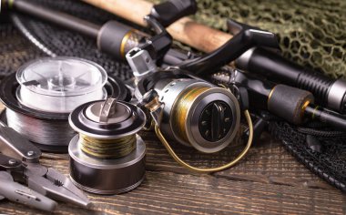 Balıkçılık çubuklar ve spinnings tablosundaki eski arka plan üzerinde balıkçılık için aksesuarlar ile kompozisyon